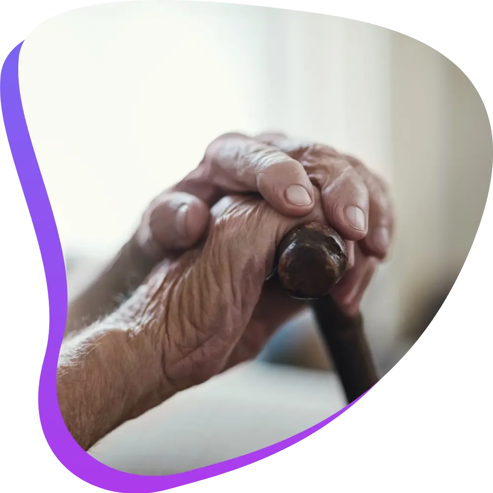 Close up of elderly hands holding walking stick